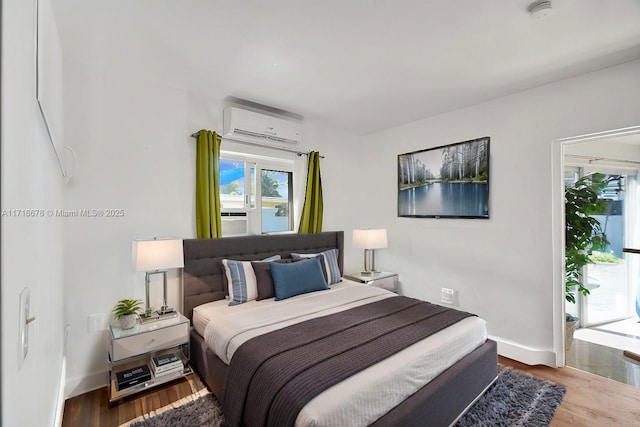 bedroom featuring an AC wall unit and hardwood / wood-style flooring