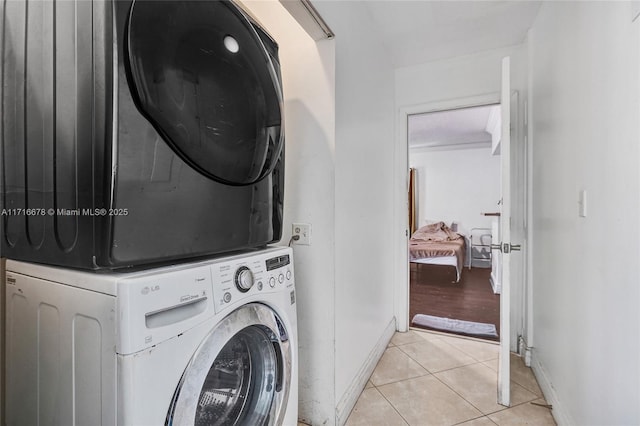 washroom featuring stacked washer / dryer and light tile patterned floors