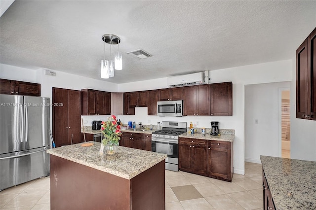 kitchen featuring sink, appliances with stainless steel finishes, decorative light fixtures, a kitchen island, and dark brown cabinetry