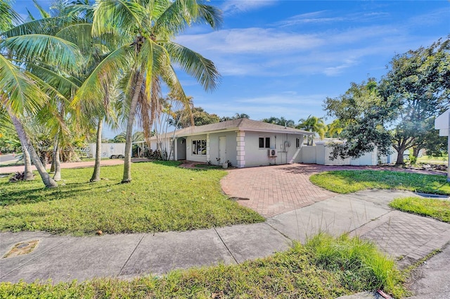 ranch-style house with fence, a front yard, and stucco siding