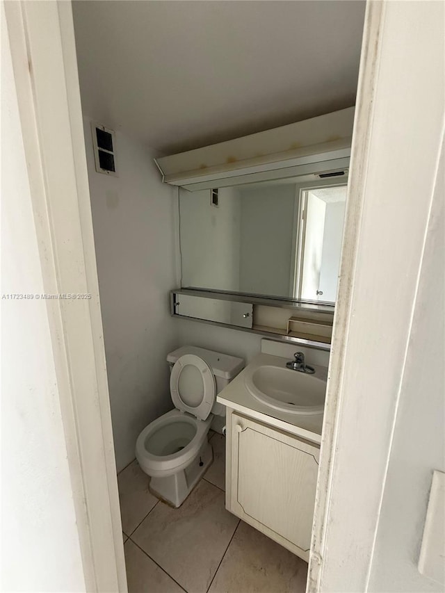 bathroom featuring tile patterned floors, vanity, and toilet