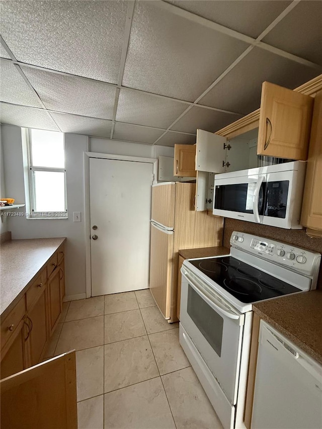 kitchen featuring a paneled ceiling, light tile patterned floors, and white appliances