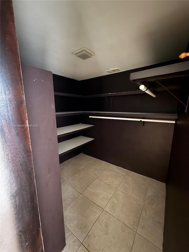 walk in closet with light tile patterned floors