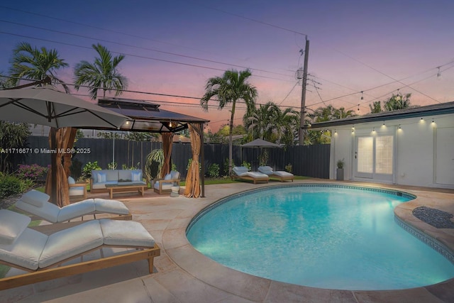 view of swimming pool featuring a fenced backyard, a fenced in pool, outdoor lounge area, and a patio