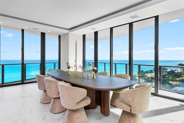 dining area with expansive windows and a water view