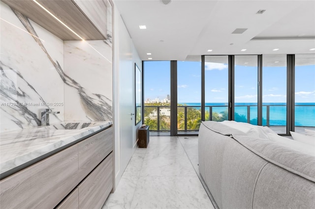 bedroom with a water view and a wall of windows