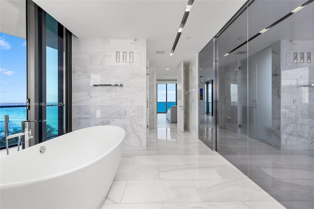 bathroom featuring a water view, separate shower and tub, and floor to ceiling windows