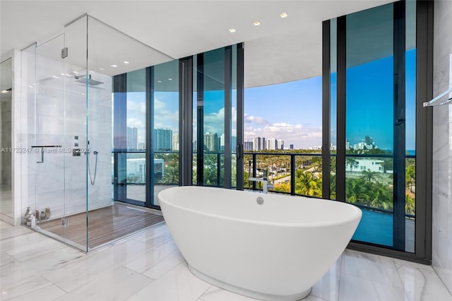 bathroom featuring a wall of windows and independent shower and bath