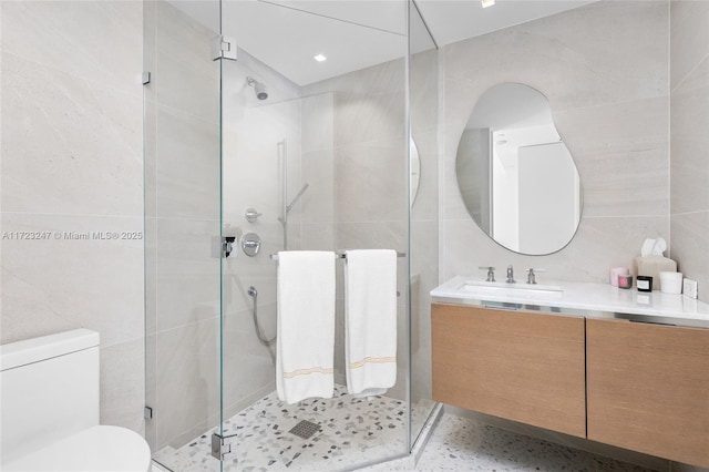 bathroom with an enclosed shower, vanity, and tile walls