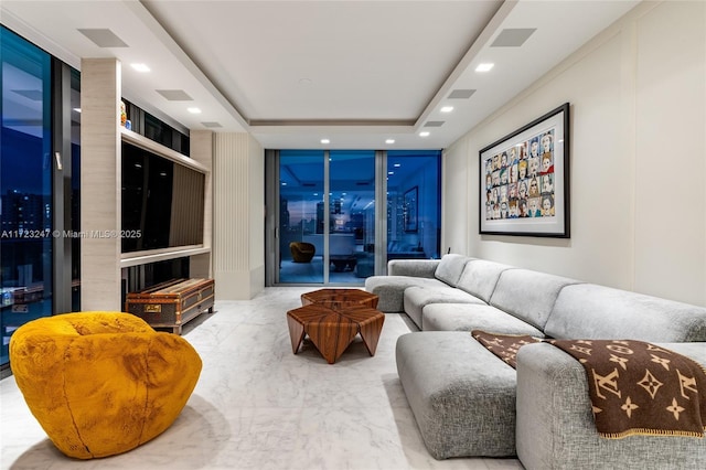 living room with a raised ceiling and a wall of windows