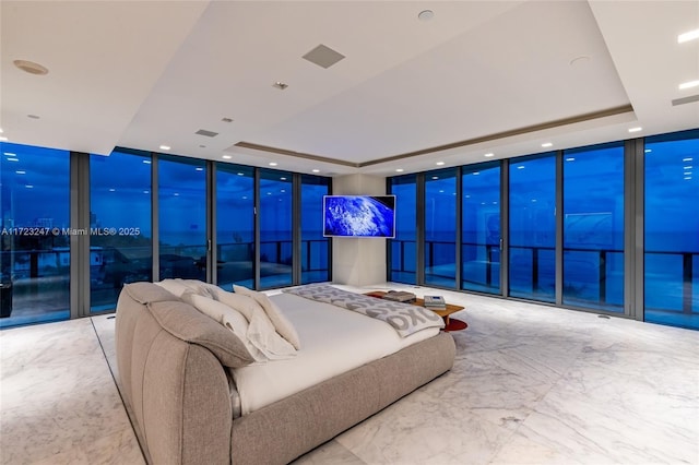 bedroom featuring expansive windows and a raised ceiling