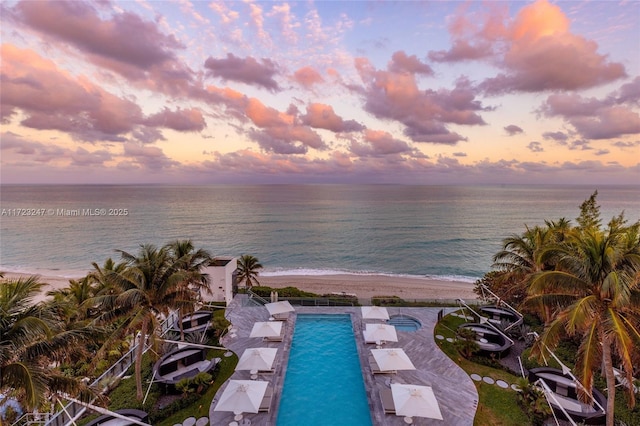 exterior space featuring a water view, a beach view, and a patio