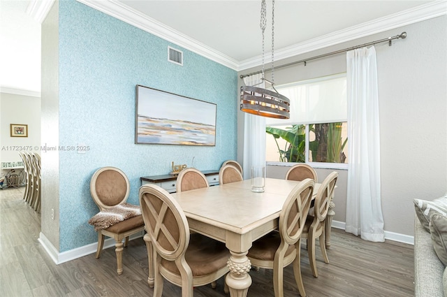 dining area featuring hardwood / wood-style flooring and crown molding