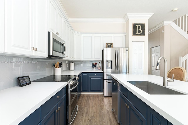 kitchen featuring blue cabinets, sink, white cabinets, backsplash, and stainless steel appliances