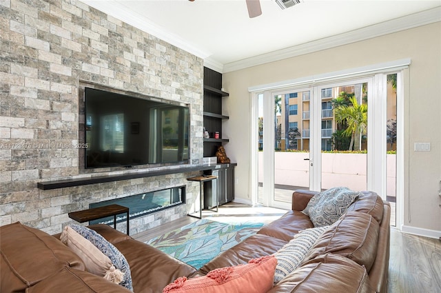 living room featuring crown molding, ceiling fan, light hardwood / wood-style floors, built in shelves, and french doors