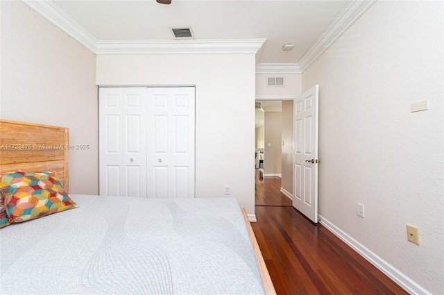 bedroom featuring crown molding, ceiling fan, dark wood-type flooring, and a closet