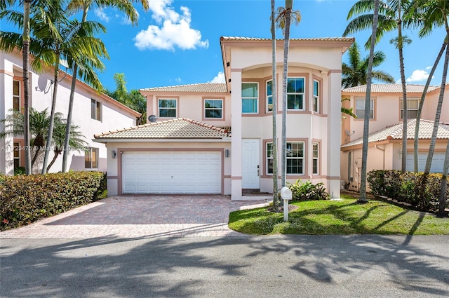 mediterranean / spanish-style house featuring a garage and a front yard