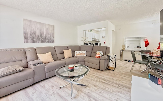 living room featuring a textured ceiling and light wood-type flooring