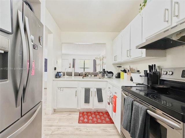 kitchen with light hardwood / wood-style floors, white cabinetry, sink, and appliances with stainless steel finishes