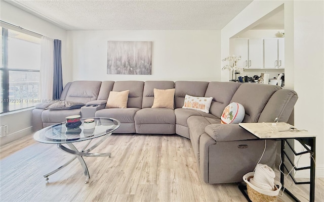 living room with light wood-type flooring and a textured ceiling