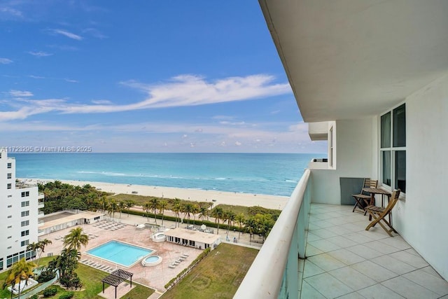 balcony featuring a view of the beach and a water view