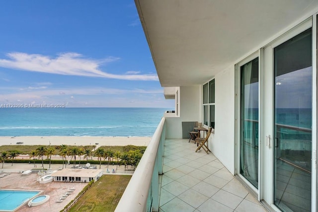 balcony featuring a water view and a beach view