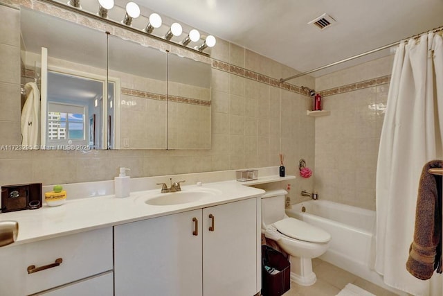 full bathroom featuring vanity, toilet, tile walls, tasteful backsplash, and shower / tub combo