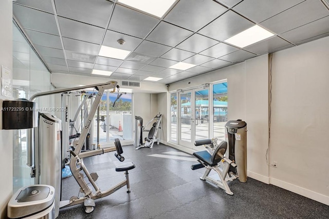 exercise room with a drop ceiling and a healthy amount of sunlight