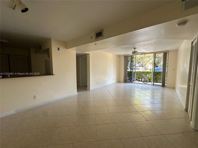 tiled spare room with ceiling fan