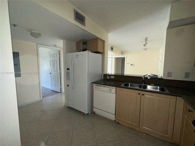 kitchen with light tile patterned flooring, white appliances, and sink