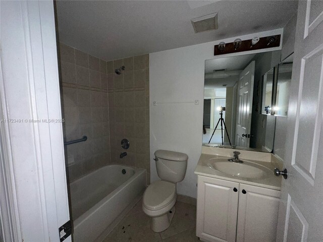 full bathroom featuring tile patterned flooring, vanity, toilet, and tiled shower / bath