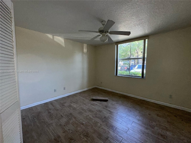 spare room with a textured ceiling, dark hardwood / wood-style floors, and ceiling fan