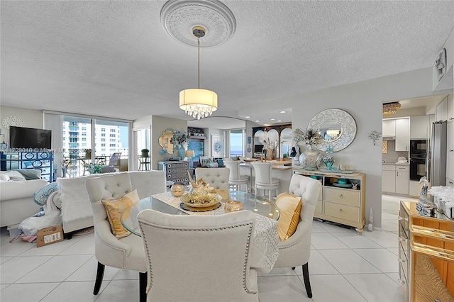 tiled dining room featuring a textured ceiling and an inviting chandelier