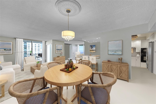 dining area featuring a textured ceiling and a notable chandelier