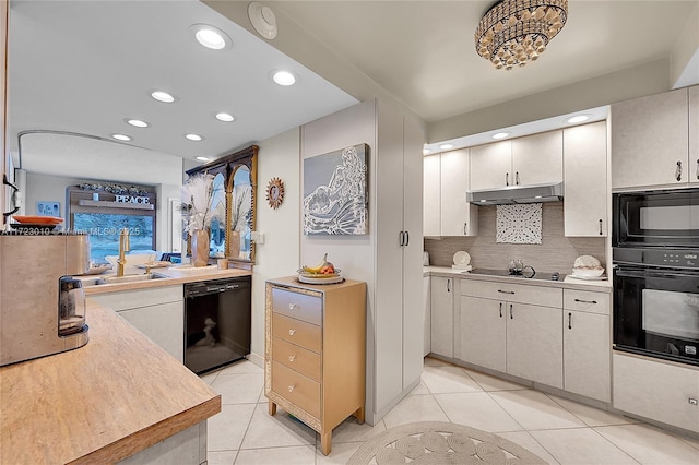 kitchen featuring tasteful backsplash, sink, light tile patterned flooring, and black appliances