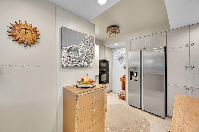 kitchen with light tile patterned floors, stainless steel refrigerator with ice dispenser, and black microwave