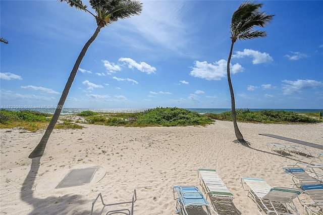 surrounding community with a water view and a view of the beach