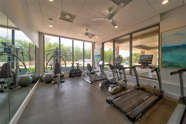 workout area with a paneled ceiling and ceiling fan