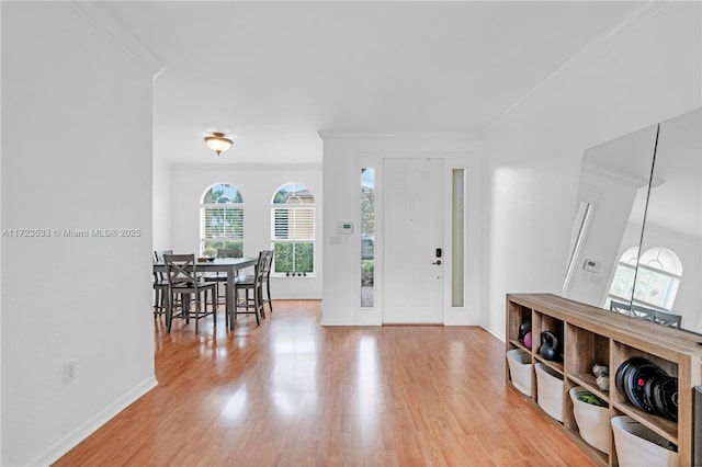 entrance foyer featuring ornamental molding and light hardwood / wood-style flooring