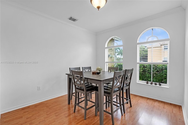 dining space featuring a healthy amount of sunlight and ornamental molding