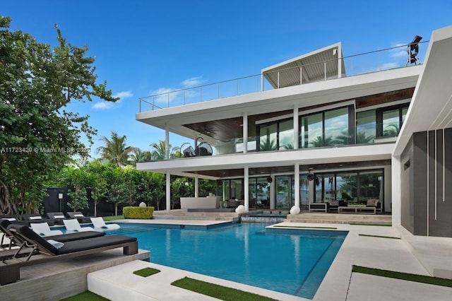 back of property with ceiling fan, a balcony, and a patio area