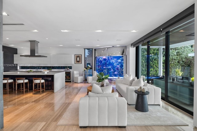 living room with expansive windows, beverage cooler, and light hardwood / wood-style floors