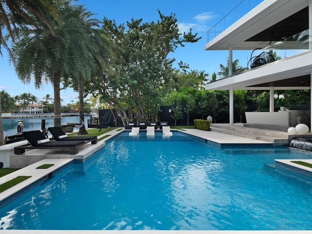 view of swimming pool featuring a water view and a patio area