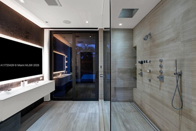 bathroom with vanity and a tile shower