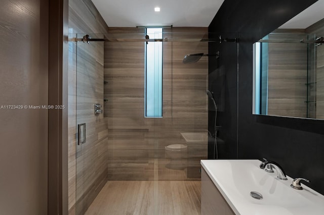 bathroom with vanity, a shower with shower door, and toilet