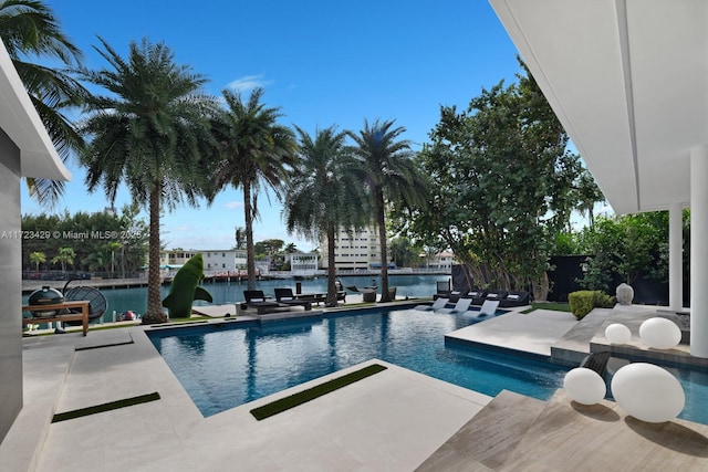 view of pool featuring a water view and a patio