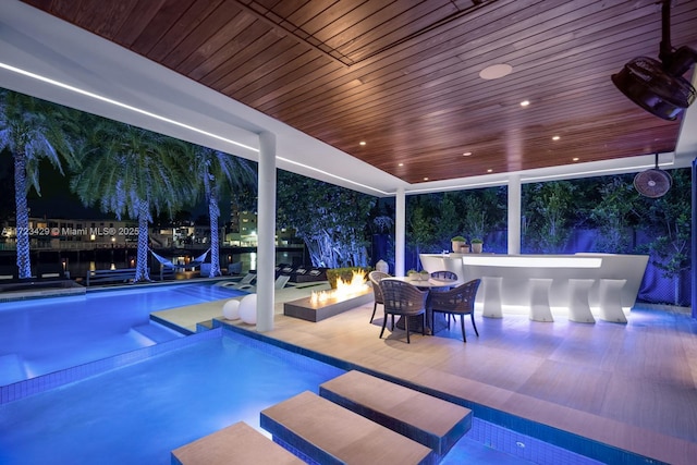 view of pool featuring a bar, a fire pit, and a patio area