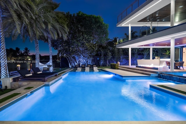 view of swimming pool featuring pool water feature, a hot tub, and a patio