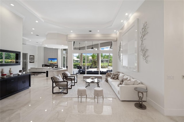 living room with a tray ceiling and ceiling fan