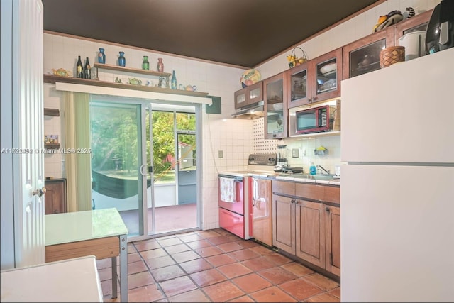 kitchen featuring sink, white refrigerator, electric stove, decorative backsplash, and light tile patterned flooring